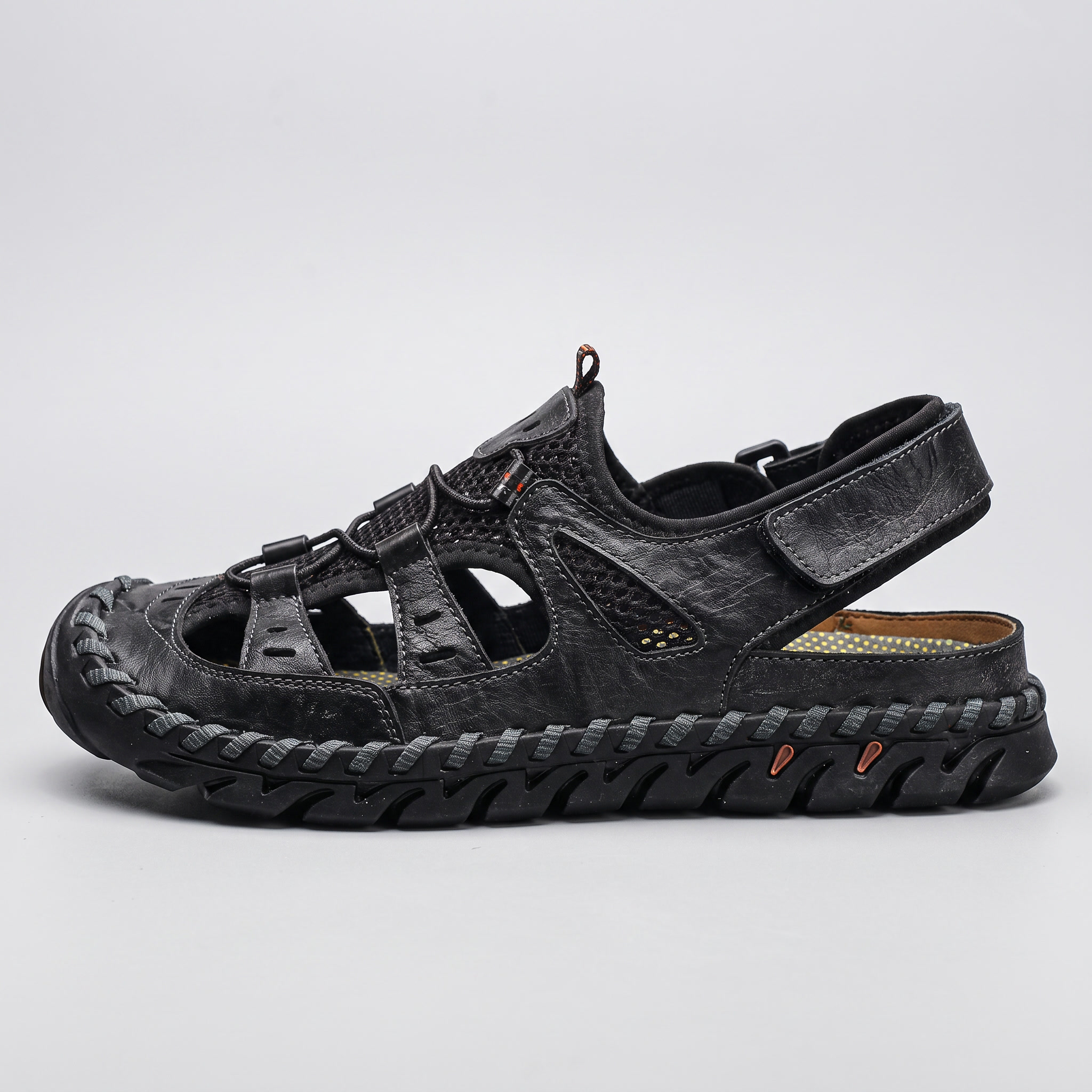 Side profile of the black closed-toe sandal showing the lugged midsole
