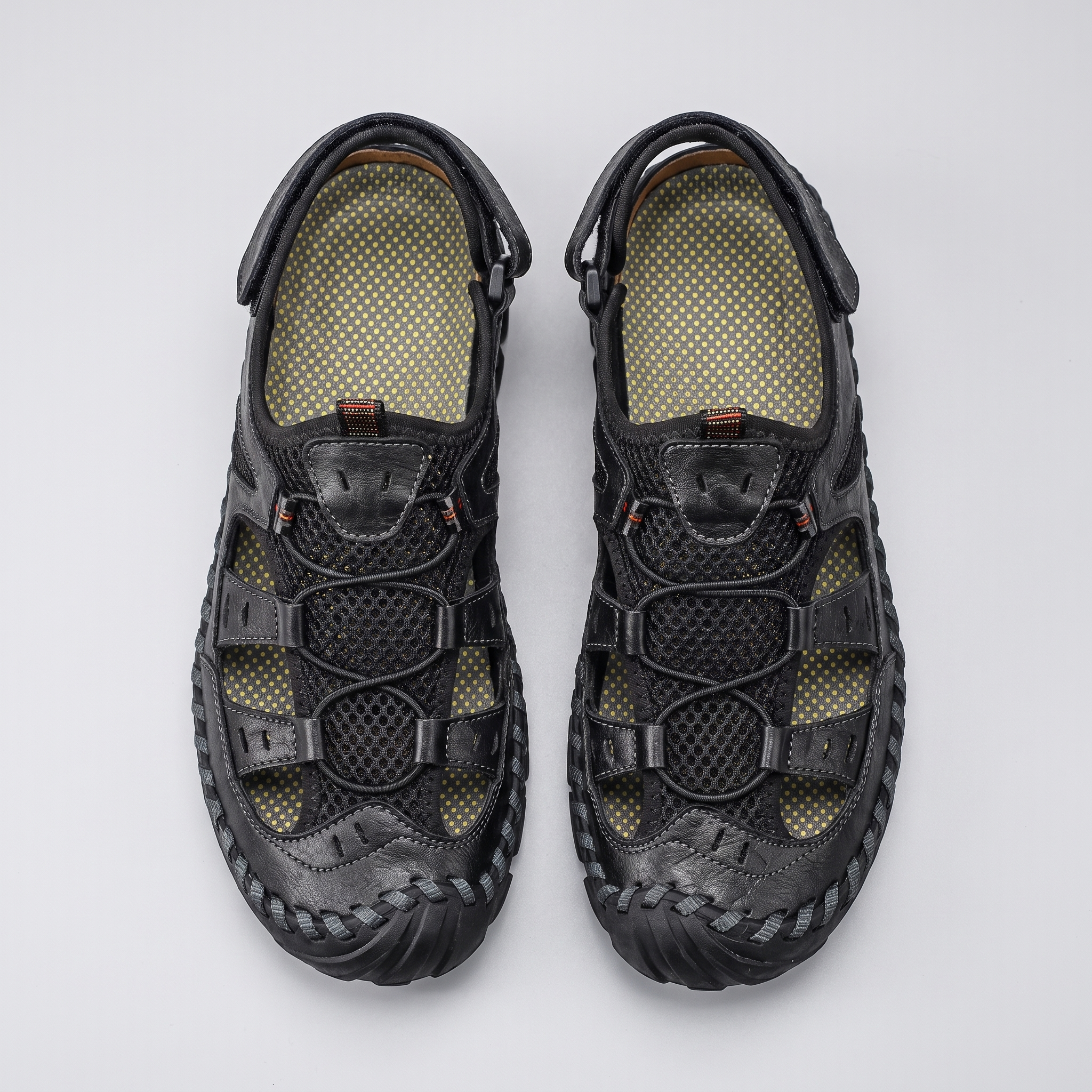 Men's closed-toe leather and mesh sandals in black, top-down pair